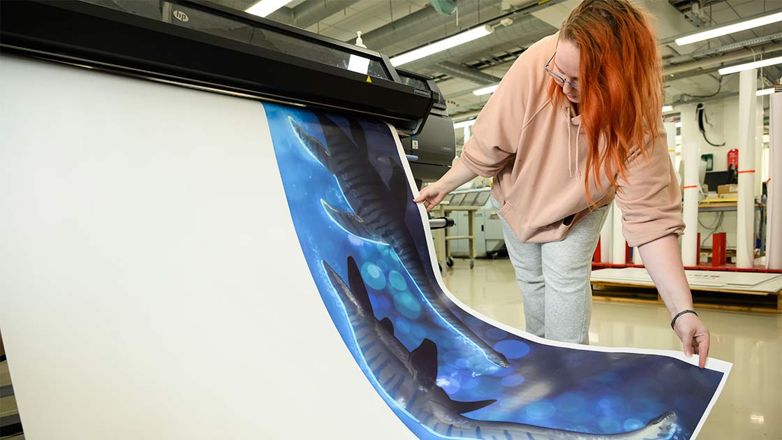 Media-alan opiskelija tulostaa harjoitustyötä.