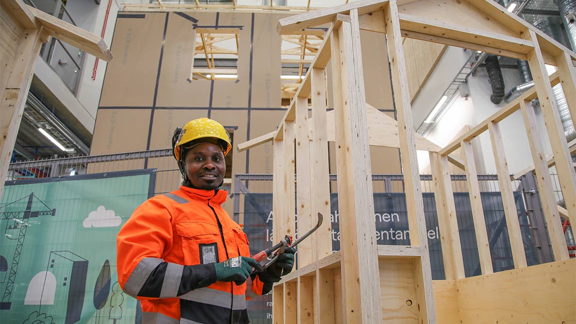 Alex esittelee rakentamansa talon runkoa.