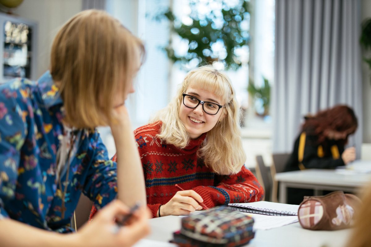 Kaksi opiskelijaa keskustelee oppitunnilla.