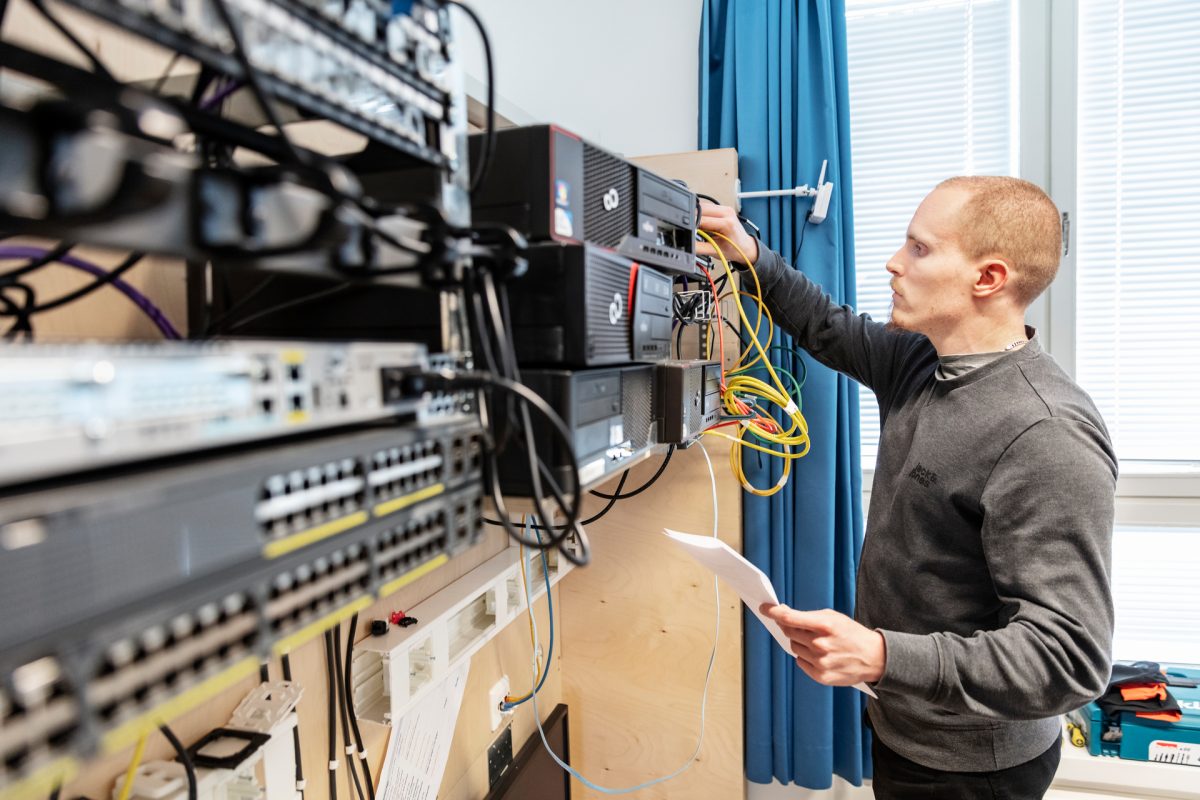 Opiskelija harjoittelee viestintälaitteiden asentamista.