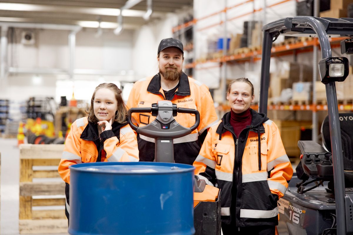 Kolme logistiikka-alan opiskelijaa harjoittelee varastotöitä.