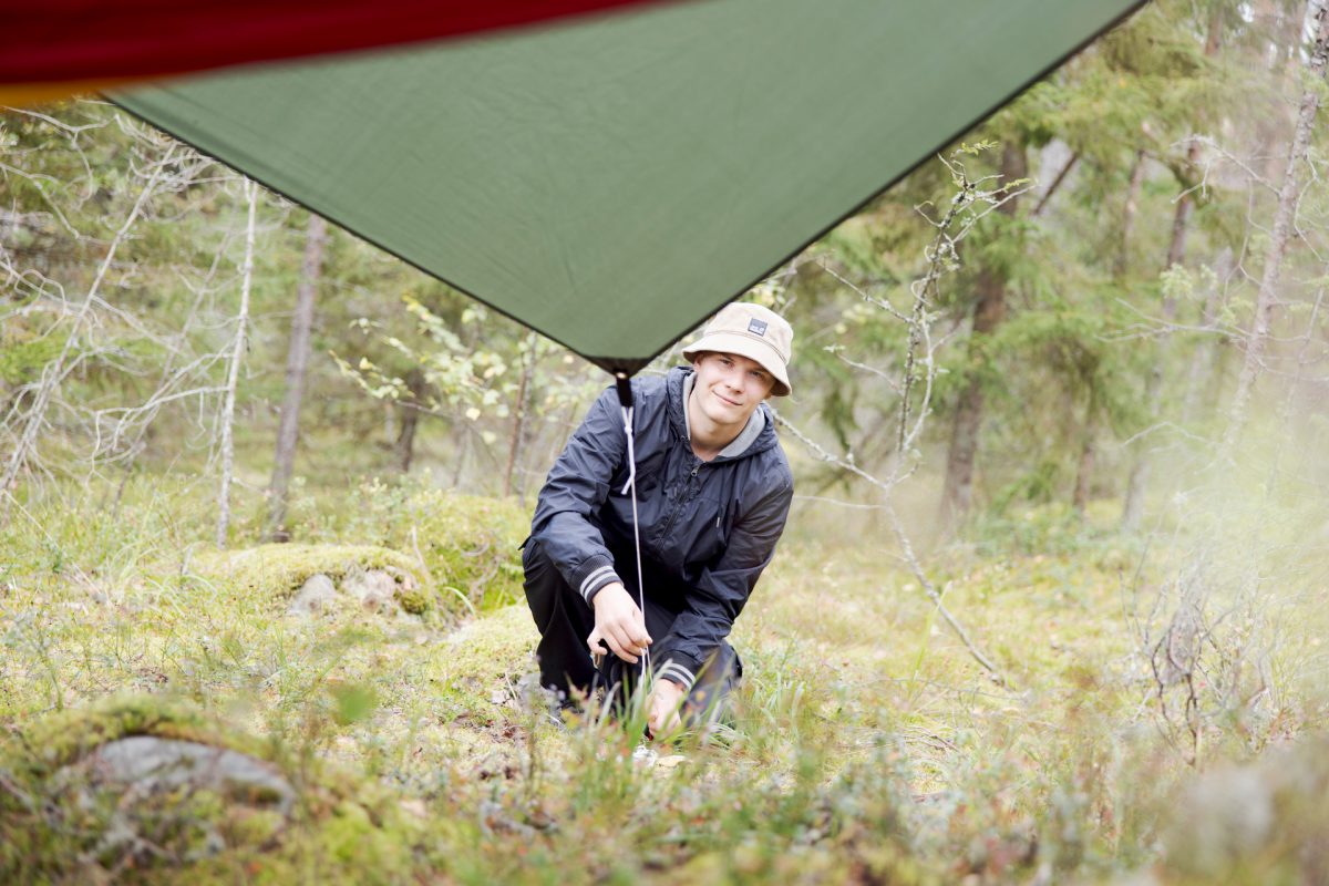 Luontoalan opiskelija pystyttää telttaa kenttäopinnoissa.