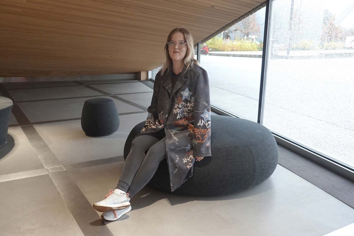 Opiskelija Christa Johansson istumassa kirjaston aulassa.