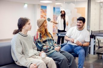 Stadin AO:n media-alan opiskelijoita yhteiskuvassa luokkatilassa.