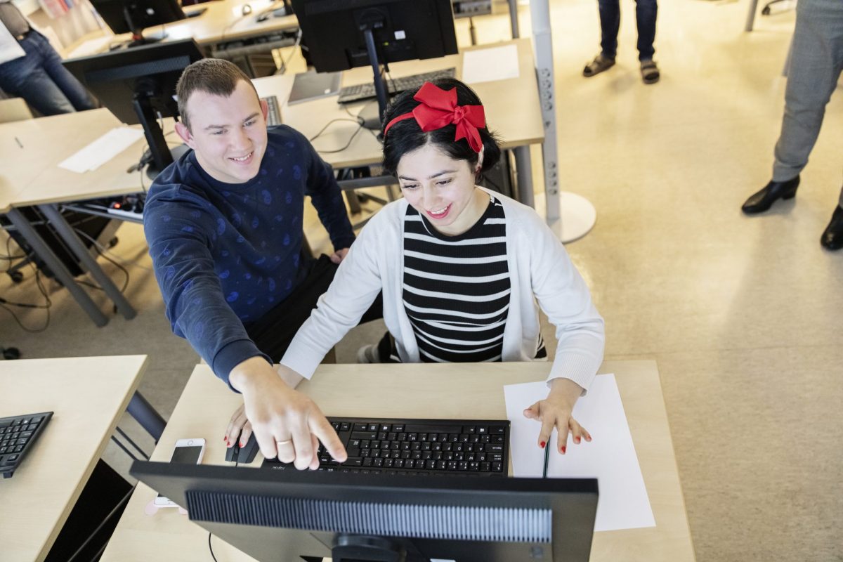 Two people by a computer.